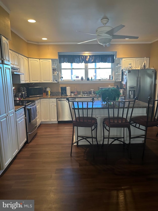 kitchen featuring a kitchen breakfast bar, stainless steel appliances, ceiling fan, white cabinets, and dark hardwood / wood-style floors