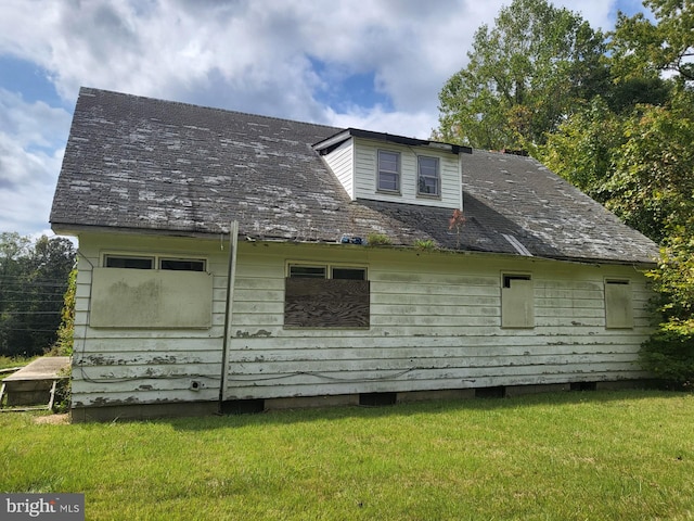 back of property featuring a lawn