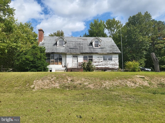 cape cod home with a front yard and a deck