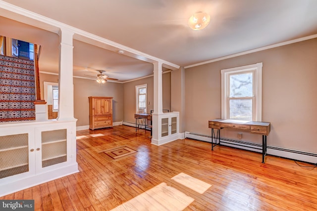 interior space with baseboard heating, light hardwood / wood-style flooring, and crown molding