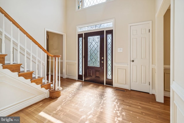 entrance foyer with hardwood / wood-style floors and a high ceiling