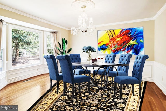 dining room with crown molding, dark wood-type flooring, and a notable chandelier