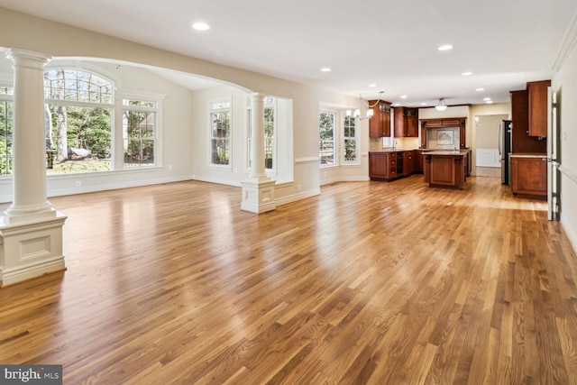 unfurnished living room with plenty of natural light and light hardwood / wood-style flooring