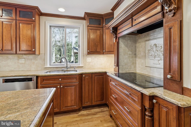 kitchen featuring dishwasher, black electric stovetop, sink, light hardwood / wood-style flooring, and decorative backsplash