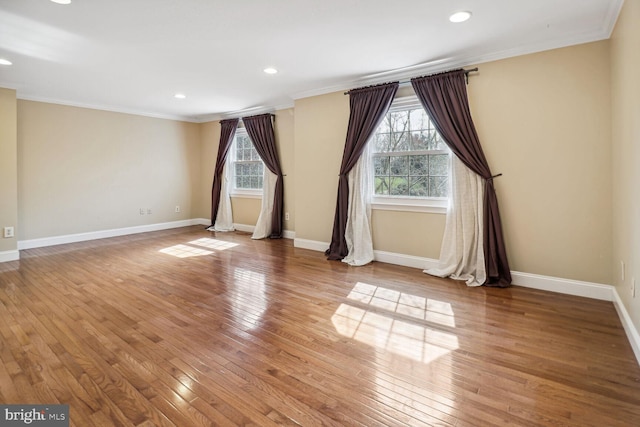 spare room with wood-type flooring, ornamental molding, and a healthy amount of sunlight