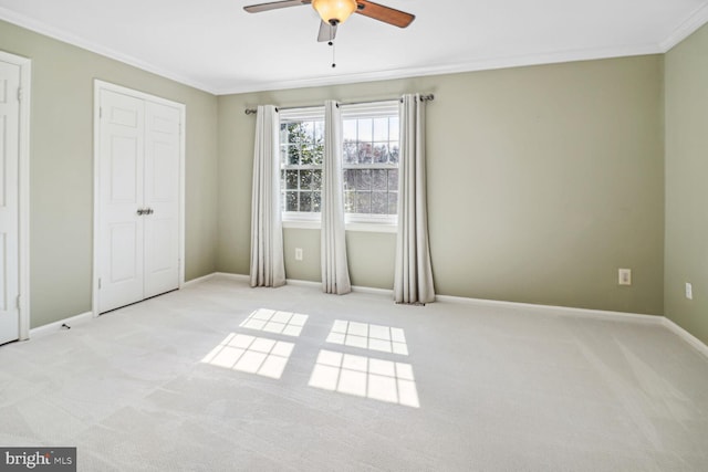 unfurnished bedroom with ceiling fan, light colored carpet, and ornamental molding