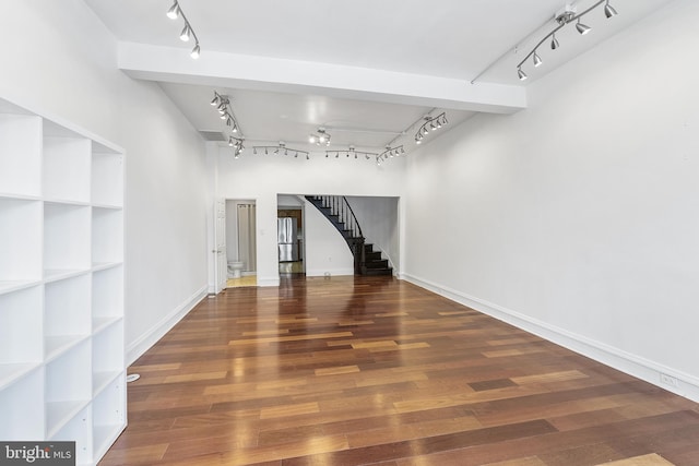 interior space with rail lighting, a high ceiling, and dark hardwood / wood-style floors