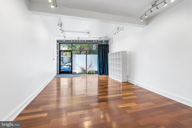 spare room featuring hardwood / wood-style floors and track lighting