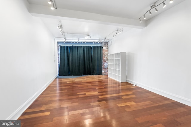 spare room featuring hardwood / wood-style flooring and rail lighting