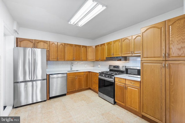 kitchen with sink, decorative backsplash, and appliances with stainless steel finishes