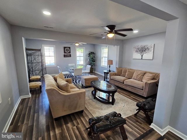 living room featuring dark wood-type flooring and ceiling fan