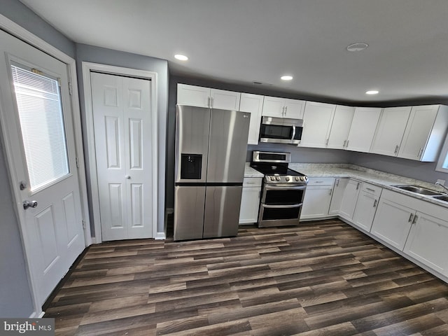 kitchen with sink, white cabinets, stainless steel appliances, and dark hardwood / wood-style flooring