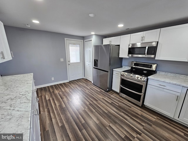 kitchen featuring dark wood-type flooring, white cabinetry, light stone counters, and stainless steel appliances