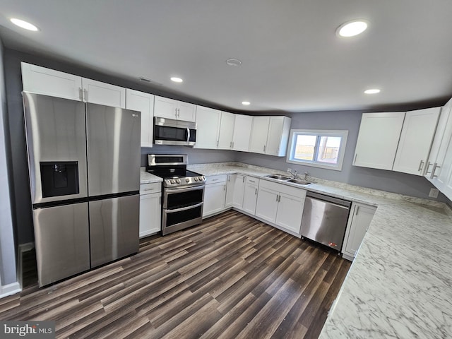 kitchen with sink, appliances with stainless steel finishes, dark hardwood / wood-style floors, and white cabinetry