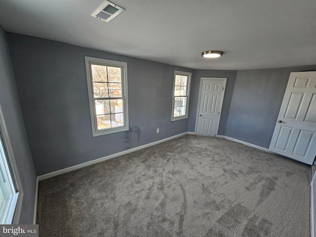 unfurnished room with a healthy amount of sunlight and carpet flooring