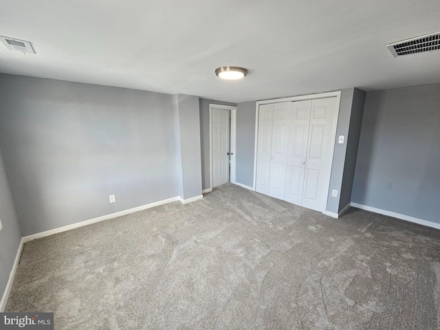 unfurnished bedroom featuring a closet and dark carpet