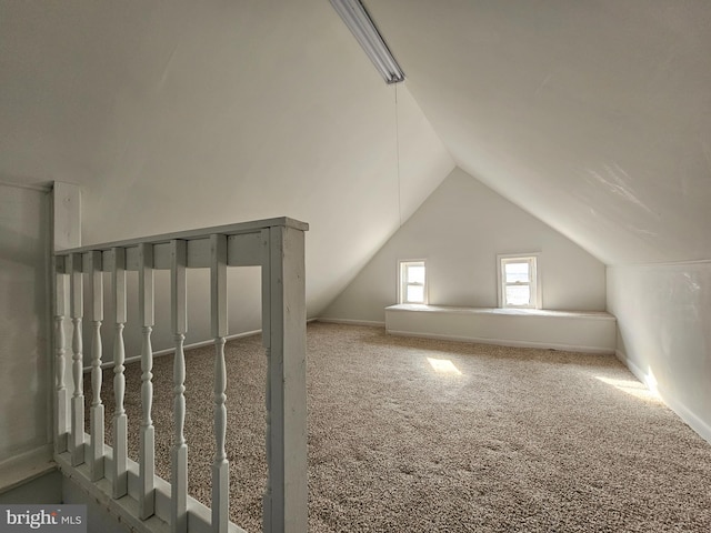 additional living space featuring vaulted ceiling and carpet floors