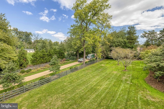 view of yard with fence and a rural view
