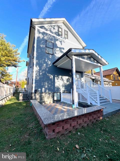 back of property with central air condition unit, a patio, and a yard