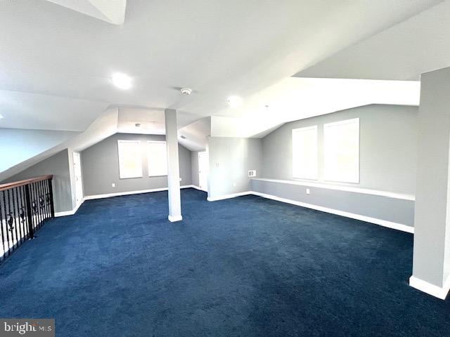 additional living space with lofted ceiling and dark carpet