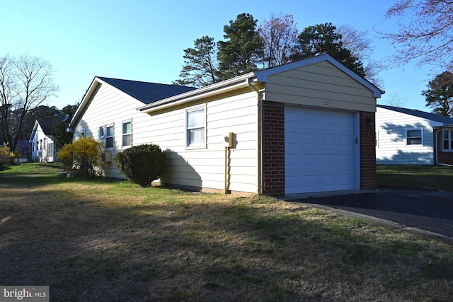 view of side of property featuring a lawn and a garage