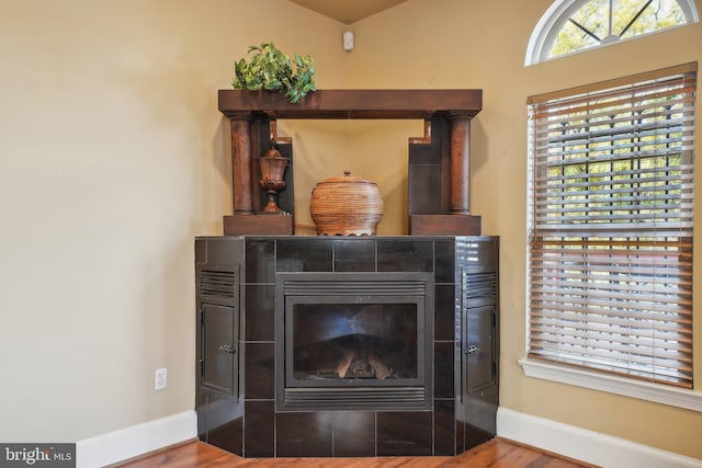 interior details featuring hardwood / wood-style floors and a tile fireplace