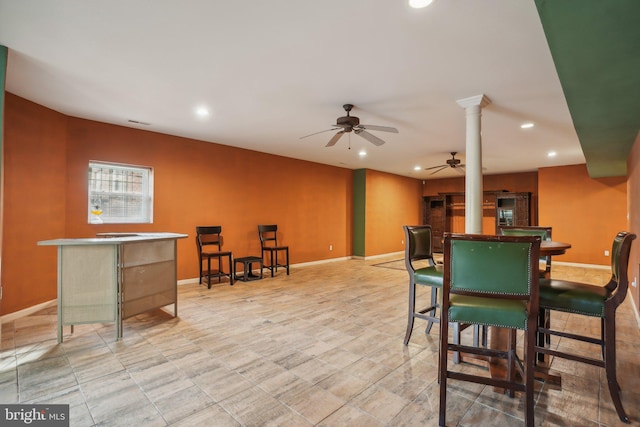 dining space featuring ceiling fan and ornate columns