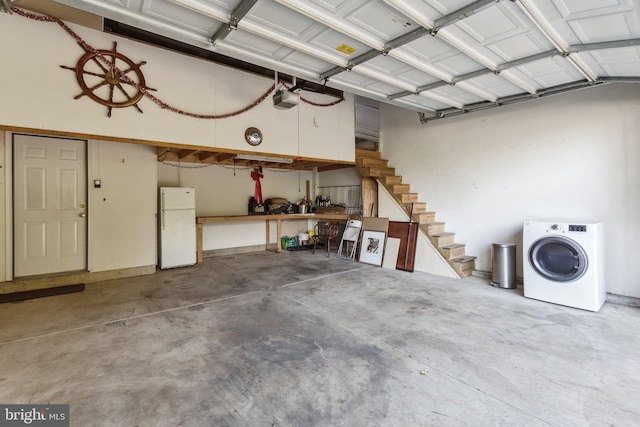 garage with a garage door opener, washer / dryer, and white fridge