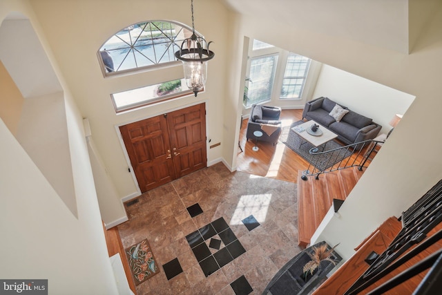 foyer featuring a high ceiling, wood-type flooring, and a notable chandelier