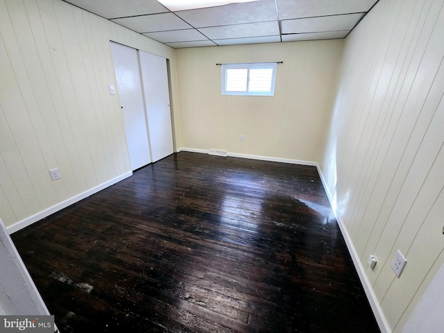 32 S F St, Keyser, WV 26726 - unfurnished bedroom with wood-type flooring, baseboards, a drop ceiling, and wood walls