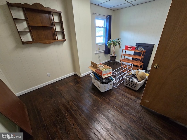 interior space featuring dark hardwood / wood-style flooring, wood walls, and cooling unit