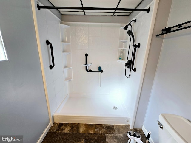 bathroom featuring tiled shower and toilet