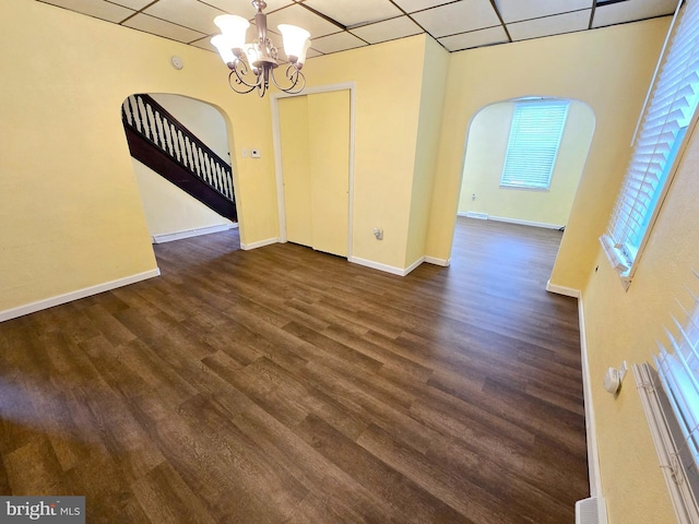 32 S F St, Keyser, WV 26726 - unfurnished dining area featuring arched walkways, a drop ceiling, a chandelier, dark wood finished floors, and stairs