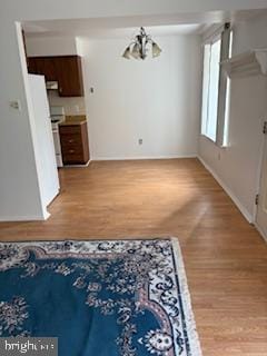 unfurnished dining area featuring light hardwood / wood-style flooring and an inviting chandelier