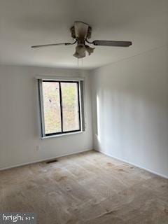 unfurnished room with light colored carpet and ceiling fan