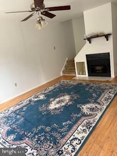 living room featuring ceiling fan and hardwood / wood-style floors