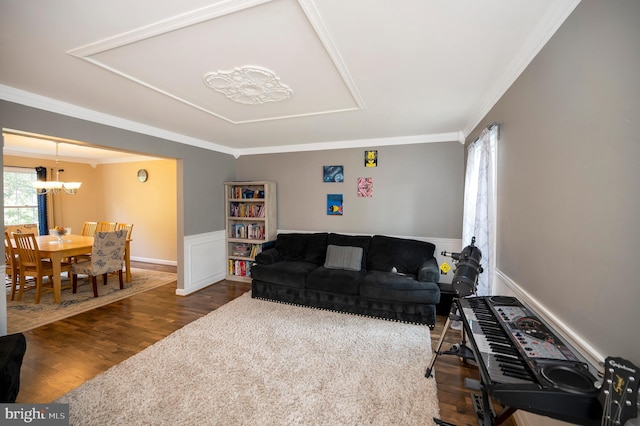 living room featuring ornamental molding, dark hardwood / wood-style floors, and an inviting chandelier