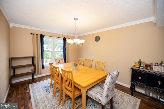 dining space featuring dark wood-type flooring, a textured ceiling, ornamental molding, and an inviting chandelier