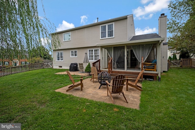 rear view of property with a patio, an outdoor fire pit, and a lawn