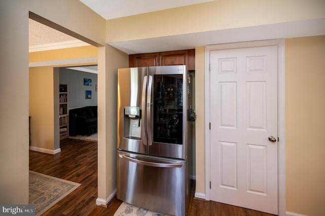 kitchen with ornamental molding, stainless steel fridge, and dark hardwood / wood-style floors