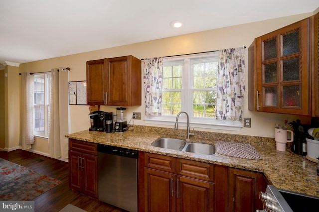 kitchen featuring appliances with stainless steel finishes, sink, light stone counters, and dark hardwood / wood-style flooring