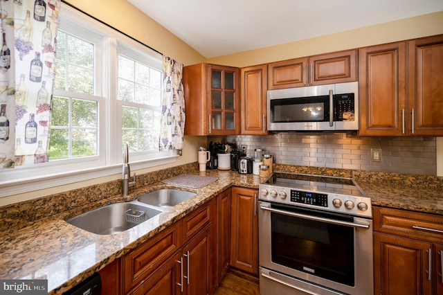 kitchen featuring light stone countertops, sink, appliances with stainless steel finishes, and backsplash