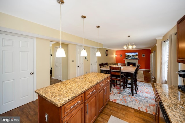 kitchen with pendant lighting, light stone countertops, and dark hardwood / wood-style floors