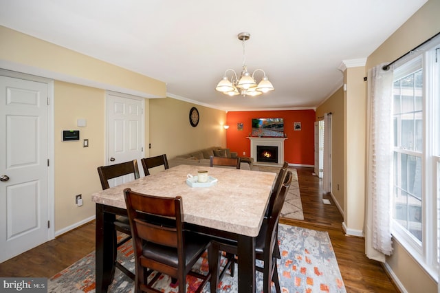 dining area with ornamental molding, an inviting chandelier, and dark hardwood / wood-style floors