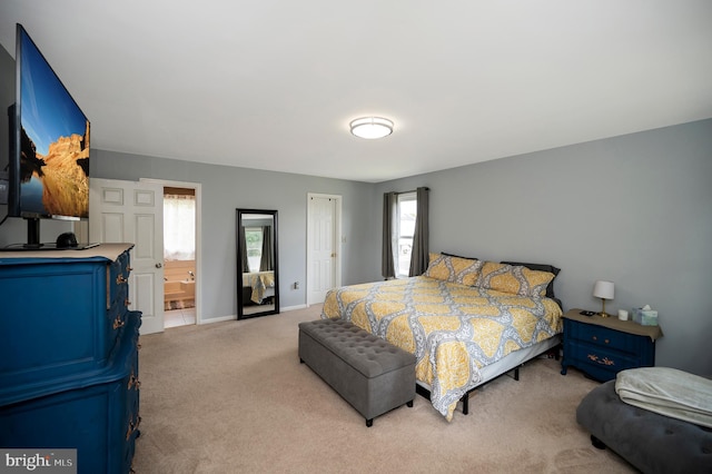 carpeted bedroom featuring ensuite bath