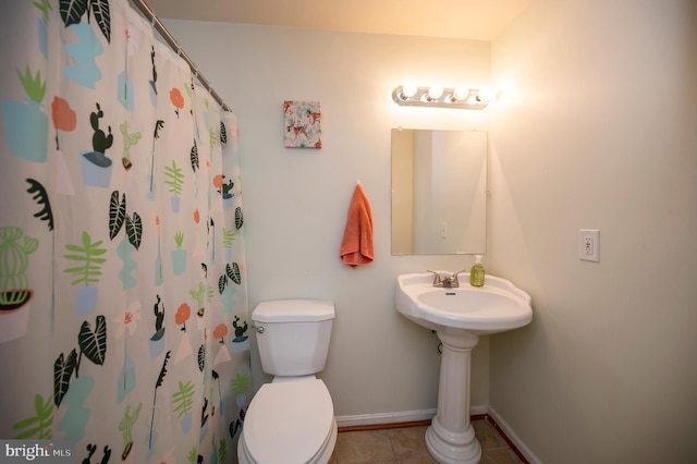 bathroom with toilet, walk in shower, and tile patterned flooring