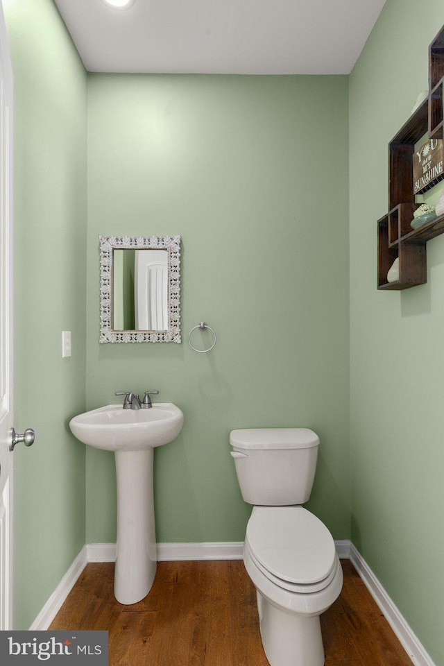 bathroom with toilet and wood-type flooring