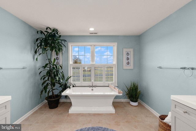 bathroom with vanity, tile patterned floors, and a washtub