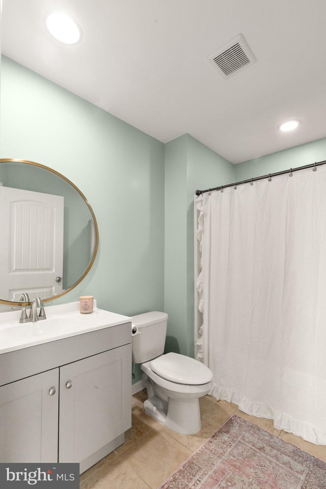 bathroom featuring tile patterned flooring, vanity, and toilet