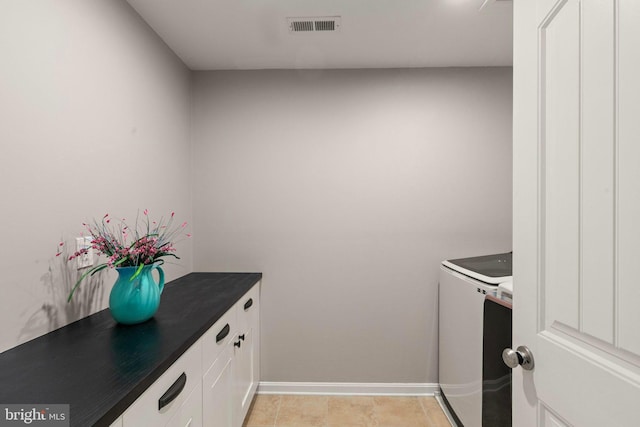 laundry area with cabinets, light tile patterned flooring, and washer and dryer